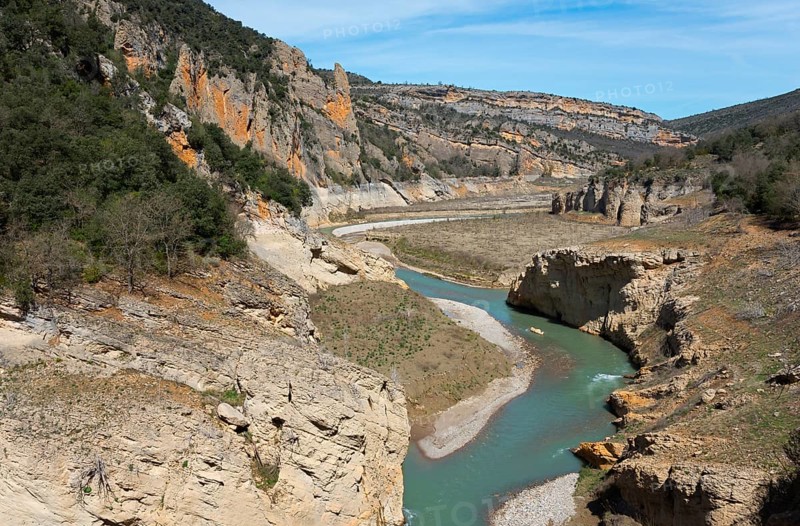A river meanders through a deep gorge in the middle of a rocky landscape under a blue sky, Noguera Ribagorçana Mont-rebei Natural Park, Montsec mountain range, Noguera Ribagorçana river, Lleida province, Catalonia, Aragon, Spain, Europe