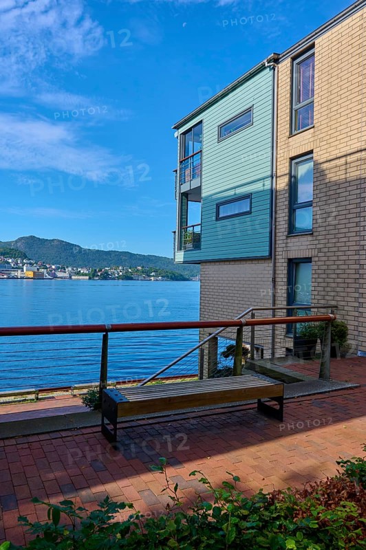 Modern residential building with several balconies and glass railings under a blue sky with clouds in a cityscape, Bergen, Vestland, Norway, Europe