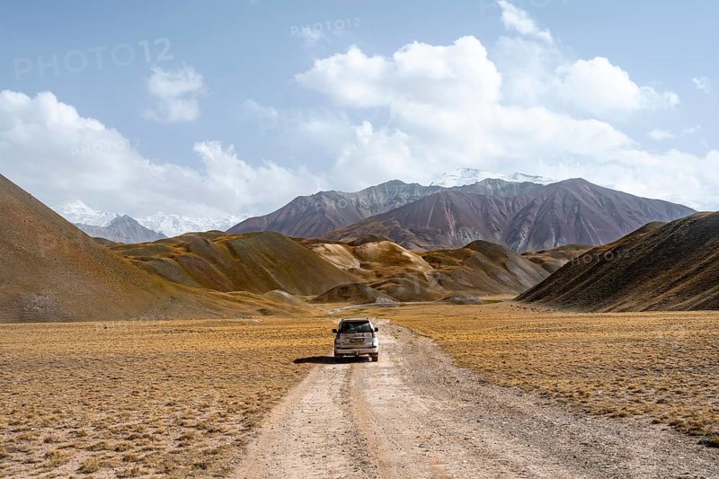 Nature tourism, road trip, overlander, off-road vehicle on a gravel road in the Pamir Mountains, Osh Province, Kyrgyzstan, Asia