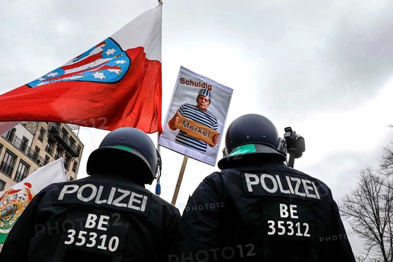 Poster shows Chancellor Merkel in prison uniform. Once again, thousands of corona deniers are demonstrating against the restrictions in the pandemic. The police broke up the demonstration for not observing the distance rule and not wearing mouth and nose protection. The police used water cannons, Berlin, 18.04.2020