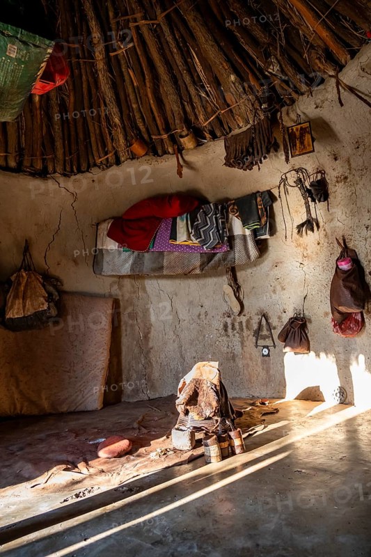 Interior of a first woman's mud hut in a Himba village, traditional containers for ochre paint and rack with leather for personal hygiene with smoke, near Opuwo, Kaokoveld, Kunene, Namibia, Africa