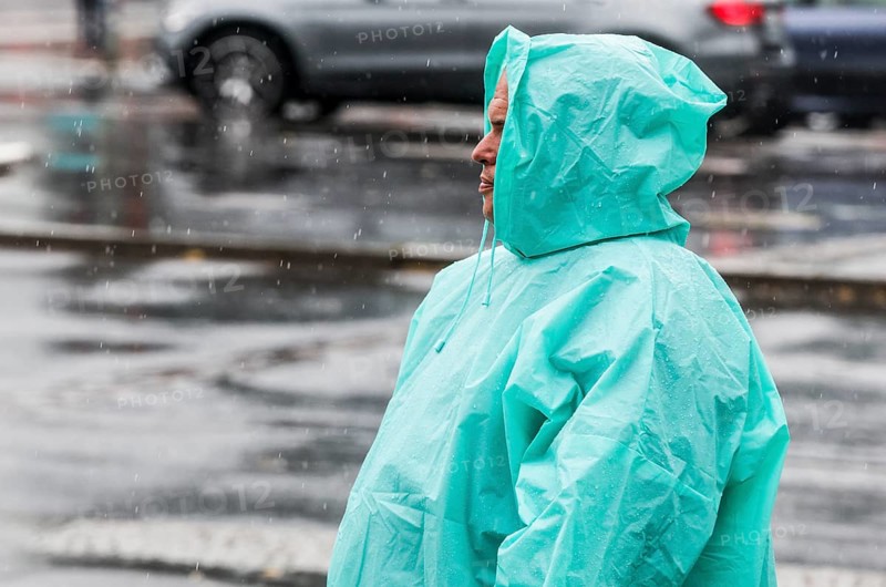 A man with a rain cape stands on a street in heavy rainfall, Berlin, 22/06/2024, Berlin, Berlin, Germany, Europe