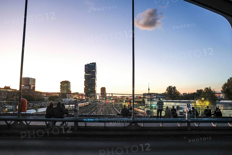 Chilling out at sunset on the Modersohn Bridge, view of railway tracks, trains and the 140 metre high Amazon office tower Edge East Side, Berlin, 23.10.2024., Berlin, Berlin, Germany, Europe