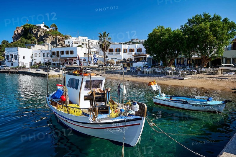 Two fishing boats moored at a harbour quay on a Greek island, surrounded by clear water and historic buildings, Skala, Patmos, Dodecanese, Greek Islands, Greece, Europe