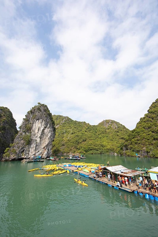 Holidaymakers queue for a kayak on a jetty, behind the karst rocks in Lan Ha Bay, Halong Bay, Vietnam, Asia