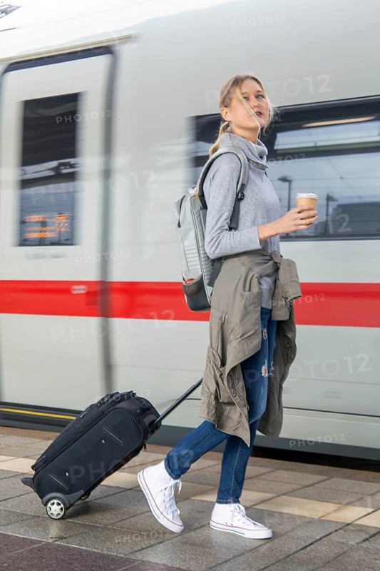 Young woman on the railway track while a train arrives