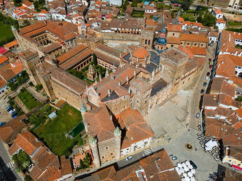 Aerial view of an old monastery with red roofs and village square, surrounded by historic buildings in medieval architecture in Spain, aerial view, pilgrimage church and monastery, Real Monasterio de Nuestra Señora de Guadalupe, Guadalupe, Cáceres province, Caceres, Extremadura, Spain, Europe