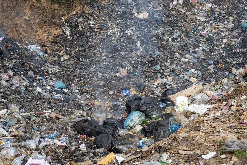 Coking rubbish dump, rubbish pit with waste and plastic rubbish, karst landscape near Vang Vieng, Vientiane province, Laos, Asia