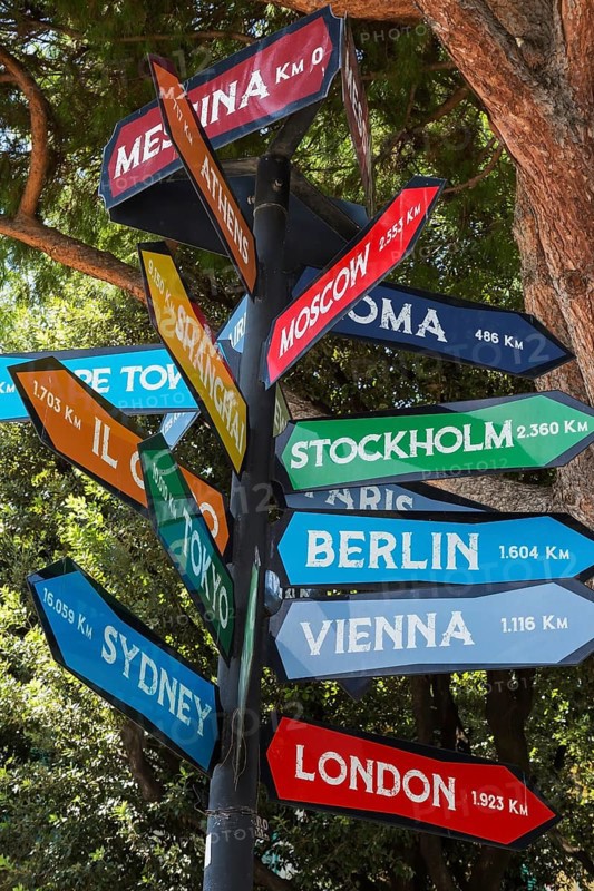 Close-up of signpost with colourful arrow markers indicating distances in kilometres to various cities in Europe and the world from Messina, Sicily, Italy, Europe