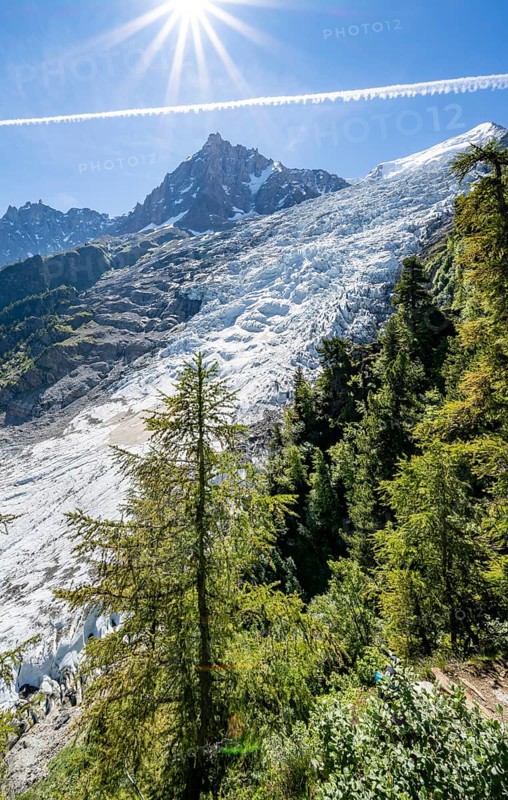 View of glacier Glacier des Bossons with sun star, behind summit of Aiguille du Midi, Chamonix, Haute-Savoie, France, Europe