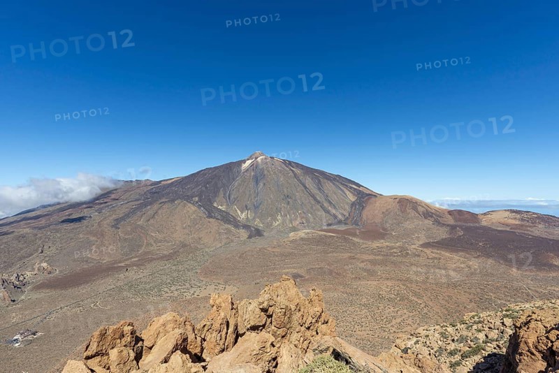 Panorama during the ascent to the Alto de Guajara, 2715m, to the bizarrely shaped rock formations of volcanic rock, Roques de García, the visitor centre and the Hotel Parador, behind it the Pico del Teide, 3717m, at sunrise, Teide National Park, Parque Nacional del Teide, Tenerife, Canary Islands, Spain, Europe