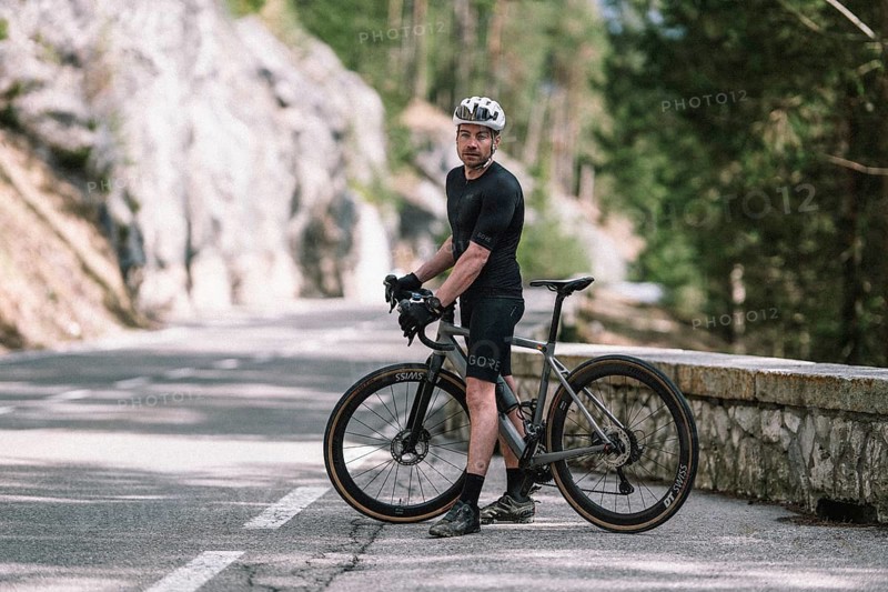 Road bike rider in spring between Lechtal and Tannheimer Tal in front of picturesque scenery of the Alps, Tyrol, Austria, Europe
