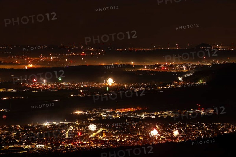 New Year's Eve fireworks 2023 at Breitenstein near Ochsenwang. View from the Swabian Alb to Göppingen and Hohenstaufen. Weilheim an der Teck in the foreground