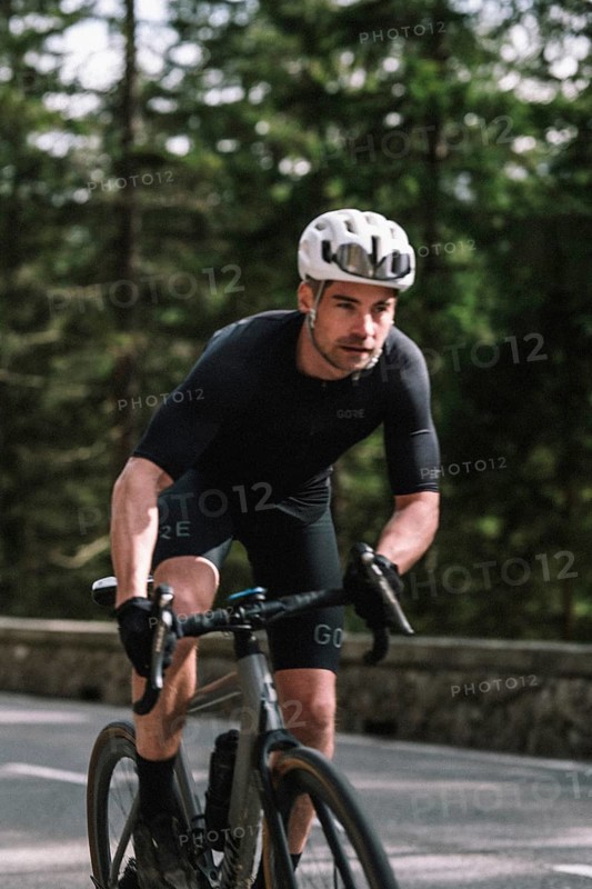 Road bike rider in spring in the Allgäu against the picturesque backdrop of the Alps, Bavaria, Germany, Europe
