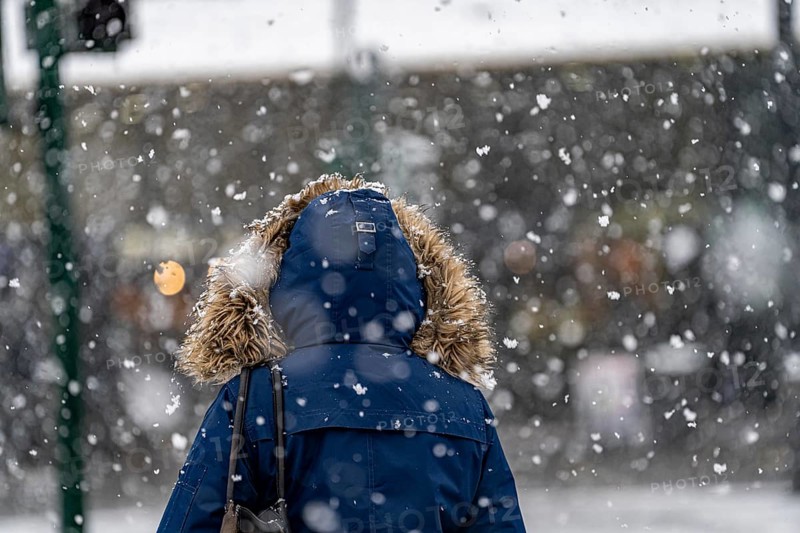 Winter weather, heavy snowfall, city centre traffic, passers-by in the snow, person with fur hood on winter jacket, North Rhine-Westphalia, Germany, Europe