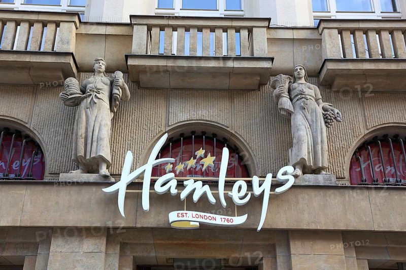Façade with the lettering of Hamleys Toy Store and two historical female figures, Prague, Czech Republic, Europe