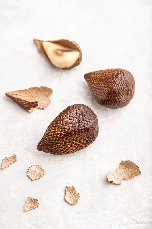 Salak or snake fruit on gray concrete background. Side view, close up, selective focus. Tropical, healthy food, summer, exotic, minimalism