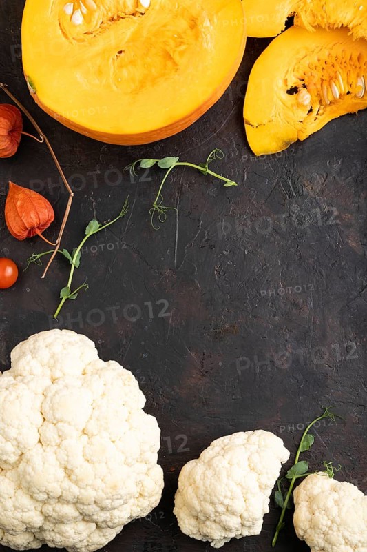Pumpkin, cauliflower, pea sprouts on a black concrete background. Top view, flat lay, copy space