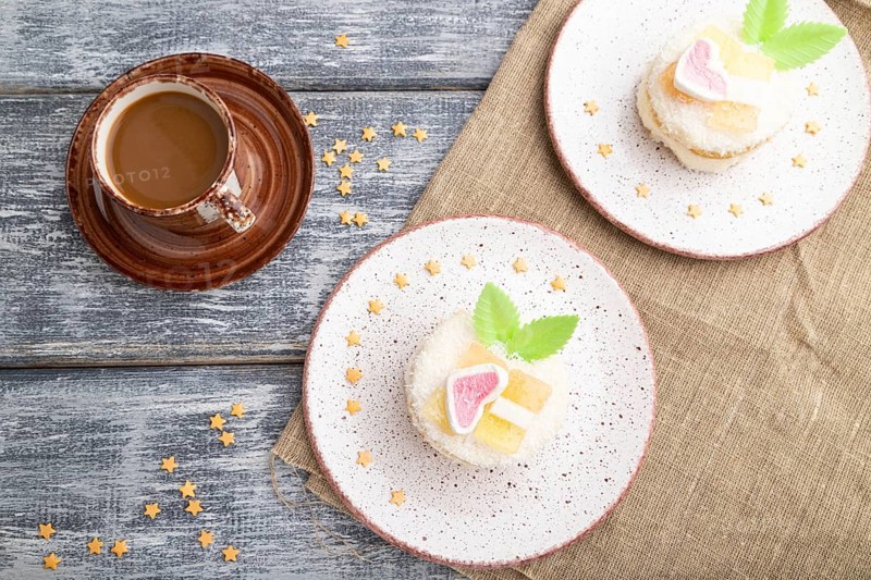 Decorated cake with milk and coconut cream with cup of coffee on a gray wooden background and linen textile. top view, flat lay, close up