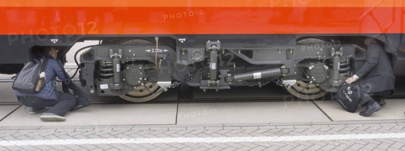 Chinese visitors to the InnoTrans trade fair in Berlin take a look at the undercarriage under a railway carriage, 20/09/2016