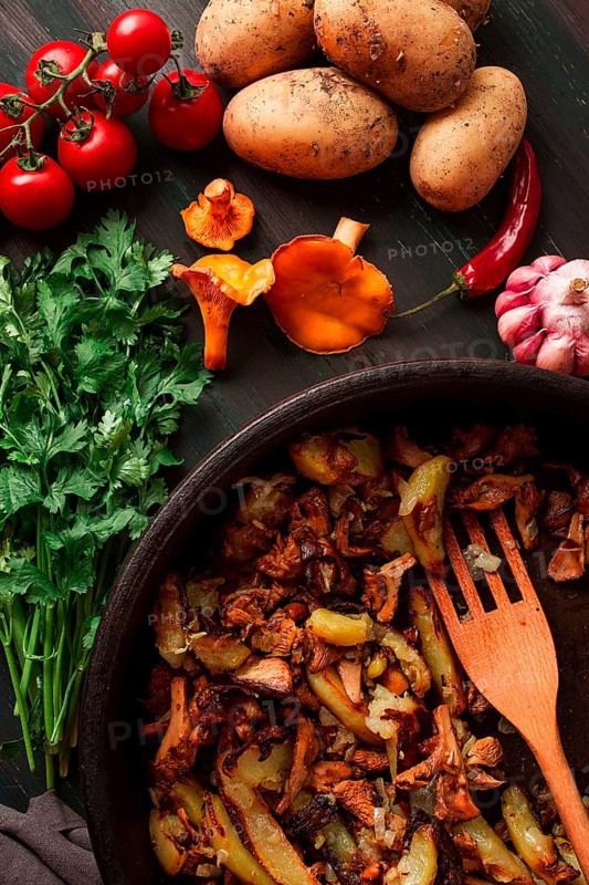 Fried chanterelles with mushrooms, in a clay pan, close-up, top view, selective focus