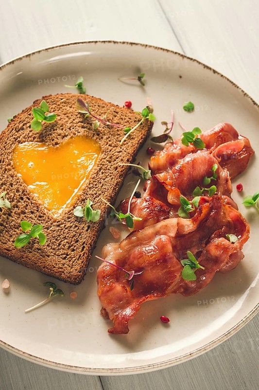 Breakfast, fried egg with bacon, micro-green, on a light background, no people, selective focus