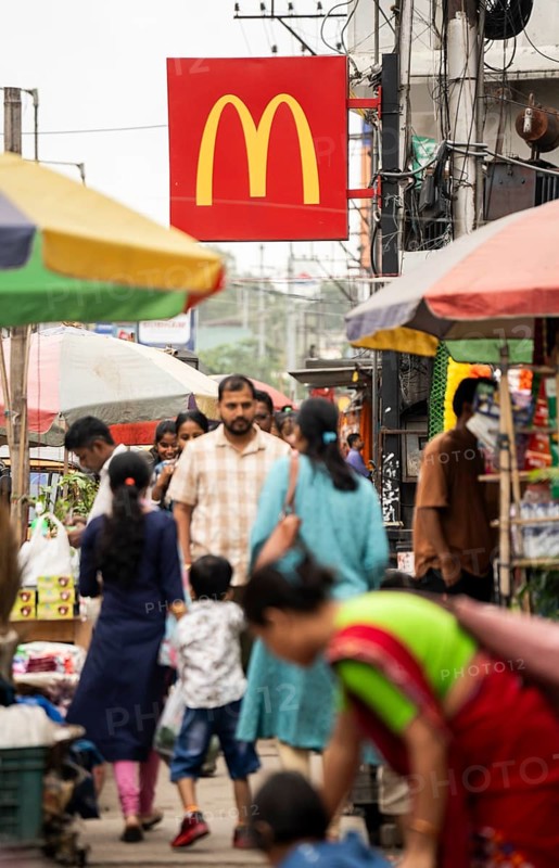 People walks by a McDonald's sign on October 26, 2024 in Guwahati, India. McDonald's recent food safety issues causing a 5% stock drop, after e-coli contamination in the United States