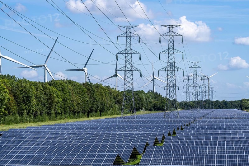 High-voltage power line route, the space underneath is used for a solar park over 5 km long, behind it a wind farm, in the harbour area of Vlissingen-Oost, Netherlands