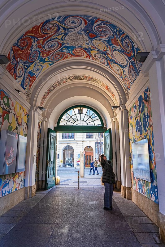 A visitor looks at the ceiling painting of a passage in the Museumsquartier, Vienna, Austria, Europe