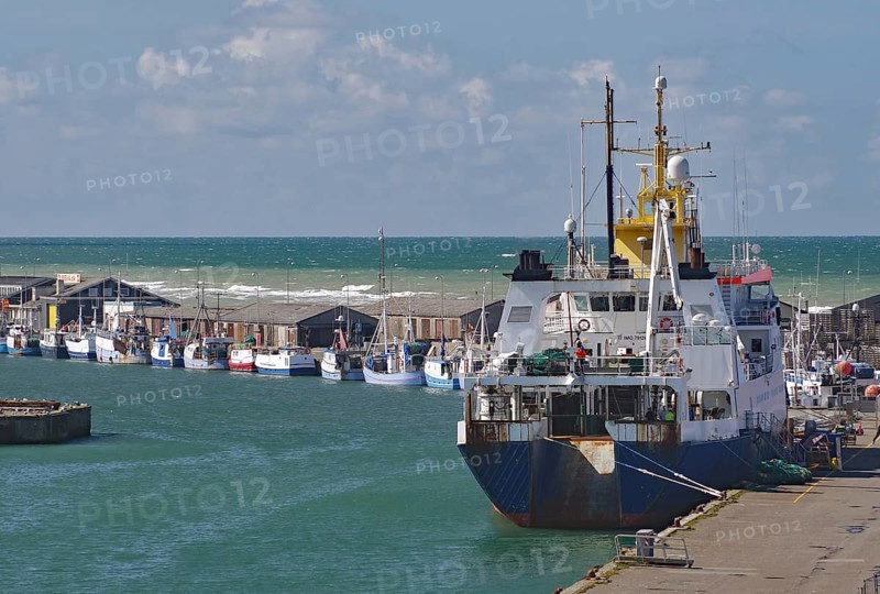 A large fishing boat moored at the harbour, with small fishing boats in the distance and the sea in the background, Hirtshals, Jutland, Denmark, Europe
