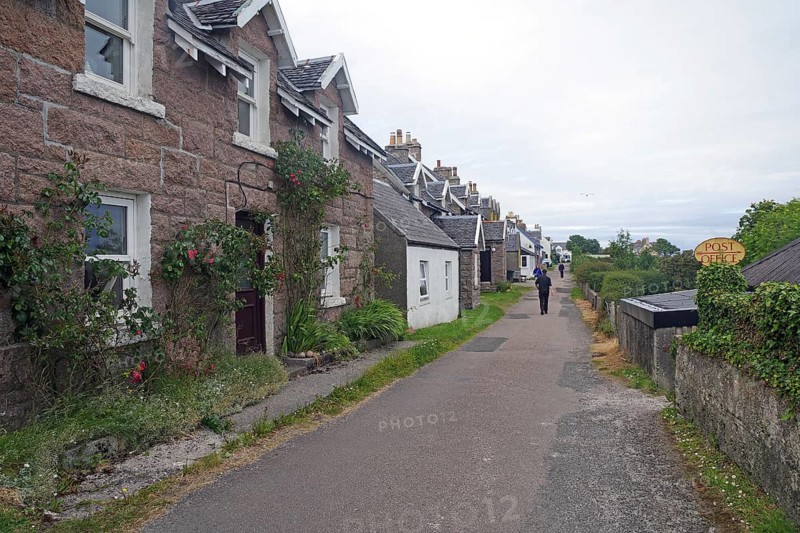 Narrow village street with traditional houses and green surroundings on a cloudy day, Iona, Inner Hebrides, Scotland, United Kingdom, Europe