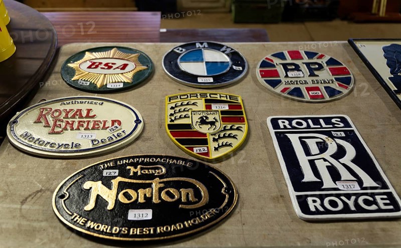 Replica reproduction metal signs related to motoring brands on display at auction, UK