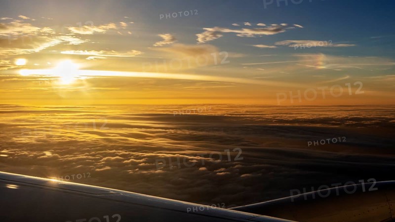 Golden sunrise over a sea of clouds, seen from an aeroplane, flight, aerial photography