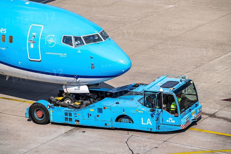 Boeing 737-800 from KLM, being driven from the terminal onto the apron, pushback, with an aircraft tug vehicle, Amsterdam Schiphol Airport, Netherlands
