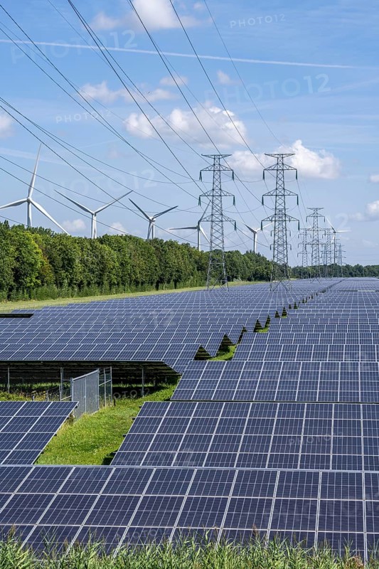 High-voltage power line route, the space underneath is used for a solar park over 5 km long, behind it a wind farm, in the harbour area of Vlissingen-Oost, Netherlands