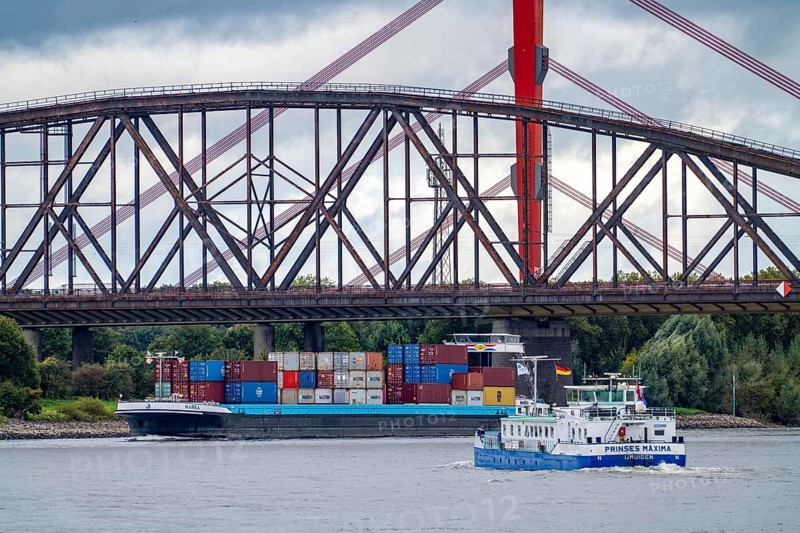 The Beeckerwerth Rhine bridge of the A42 motorway, truck traffic, in front of it the Haus-Knipp railway bridge, cargo ship on the Rhine near Duisburg, North Rhine-Westphalia, Germany, Europe
