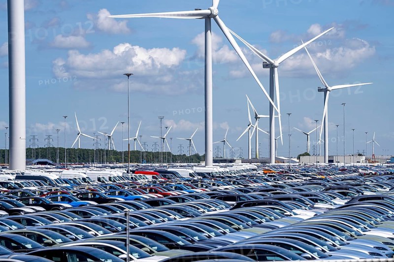 Storage area for new cars in the port of Vlissingen-Oost, vehicles are temporarily stored on over 100 hectares to ship them from Europe to the United Kingdom, Ford cars, others such as models from the Chinese car manufacturer BYD are delivered from here in Europe, wind farm, Netherlands