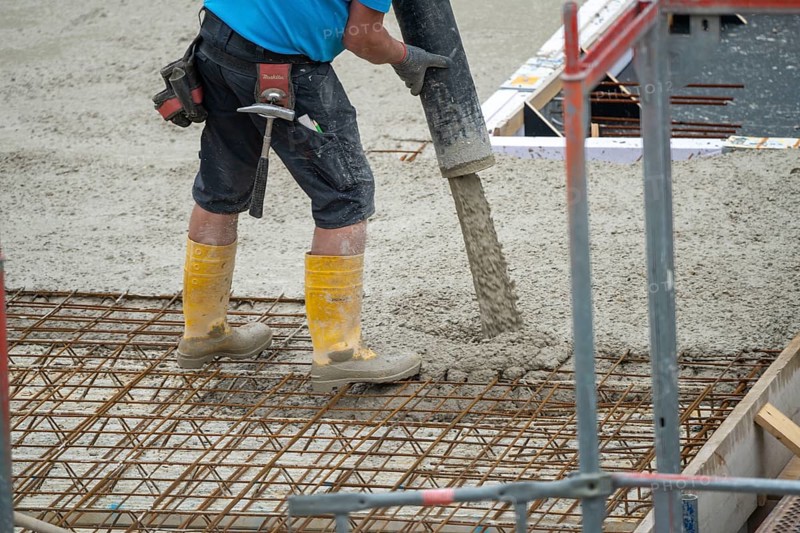 Construction site, concreting, the floor slab of a building is concreted, the concrete is pumped onto the reinforced concrete mats, spreading the concrete
