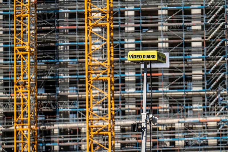 Construction site, at the Cologne Trade Fair Centre, new construction of a high-rise office building, construction cranes, facade of the shell, scaffolding, Video Guard video surveillance of the construction site, North Rhine-Westphalia, Germany, Europe