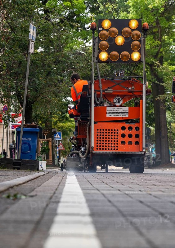 Application of road markings for a cycle lane, Rüttenscheider Straße in Essen, in the shopping and gastronomy district, cyclists have right of way over motorised vehicles, part of a cycle axis through Essen's city centre
