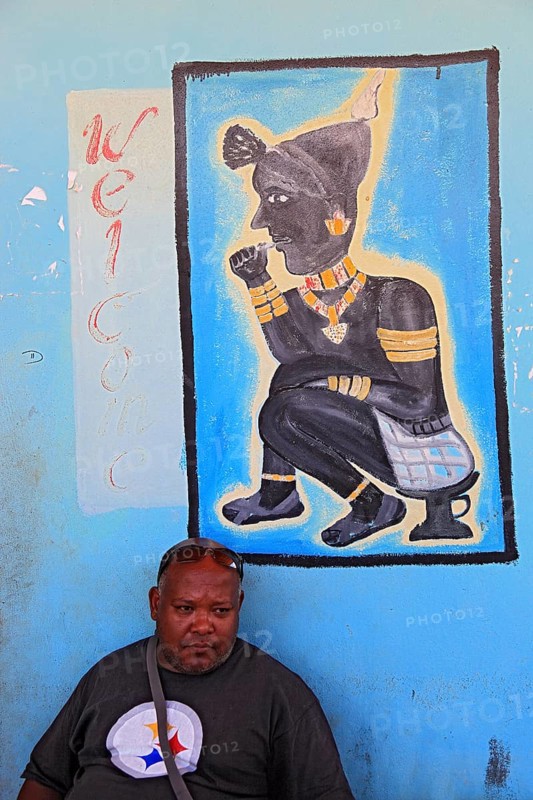 South Ethiopia, in Dimeka, local man sitting in front of a painting in a cafe, Ethiopia, Africa