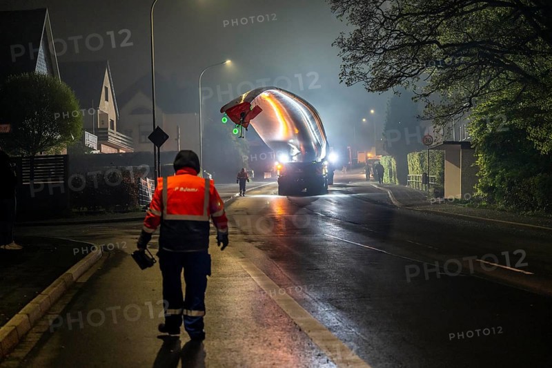 Transport of a 68 metre long, 22 tonne blade of a wind turbine, here in Breckerfeld, with a self-propelled Blade-Lifter vehicle, over a 40 km long route, over 2 nights, in the Bergisches Land, through towns, villages, over country roads, narrow through roads, to the construction site of the wind turbine near Hagen, North Rhine-Westphalia, Germany, Europe