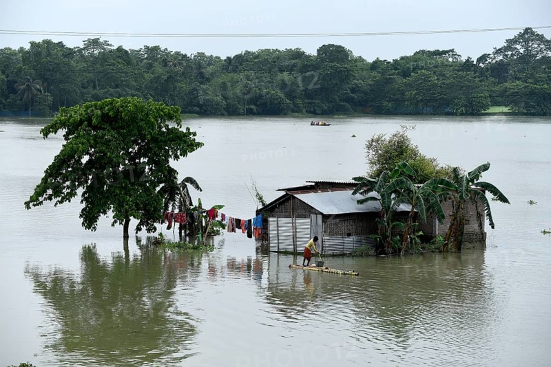 Villagers cross a flooded area on a raft, at Buraburi village in Morigaon district of Assam in India on Wednesday, July 1, 2020