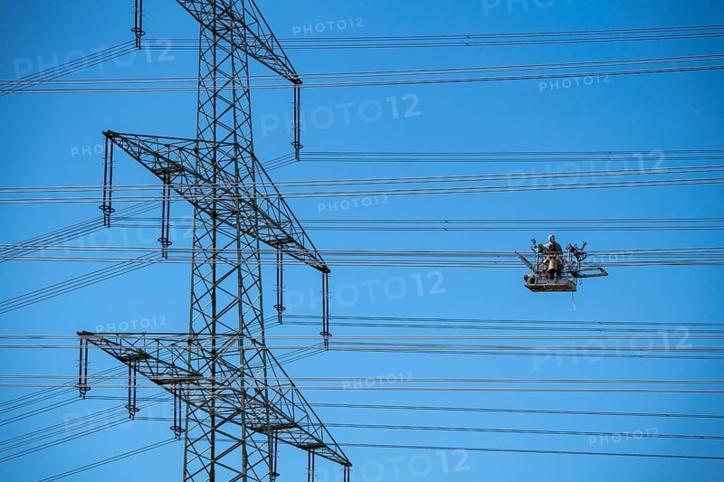 Construction of a new line route, 380 KV extra-high-voltage line between Osterath and Gohr, near Neuss, fitters in line trolleys, on the conductor cables, installing field spacers at great heights, North Rhine-Westphalia, Germany, Europe