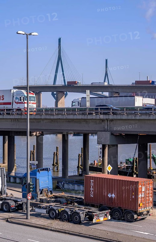 The Köhlbrand Bridge in the Port of Hamburg, rear, front trucks on the Waltershoferdam, access to the HHLA Container Terminal Burchardkai, middle traffic on the A7 motorway, spans the 325 m wide Köhlbrand, an arm of the Süderelbe, the bridge is over 3600 metres long, 53 metres above the water, piers 135 m high, more than 30, 000 vehicles use the B3 bridge daily, important connection to the port, it is dilapidated, is to be rebuilt, Hamburg, Germany, Europe