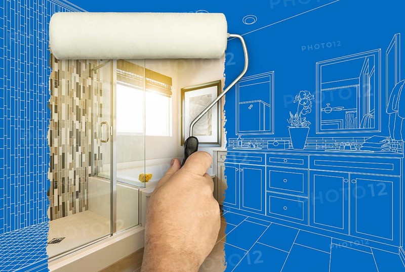 Before and after of man painting roller to reveal newly remodeled master bathroom under blueprint drawing plans