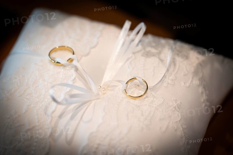 Wedding rings on an ornate white cushion
