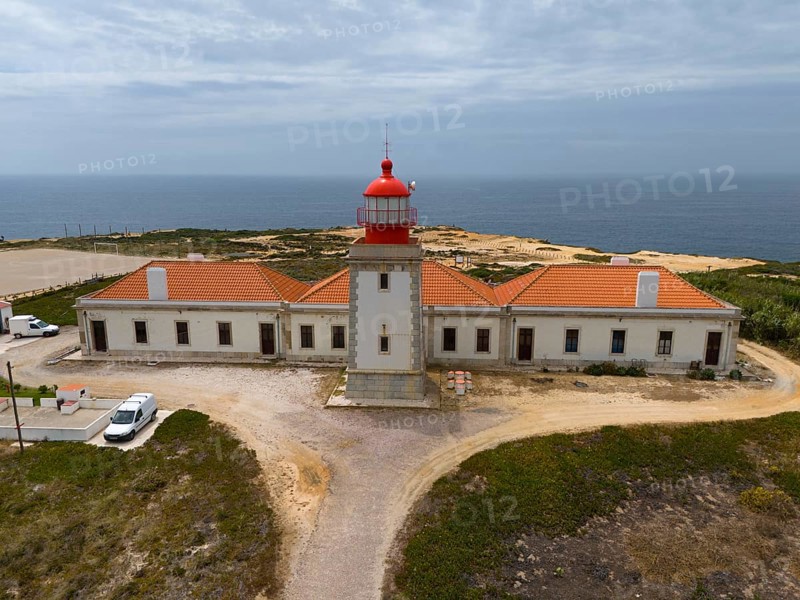 Lighthouse and long building along the coast, with view to the sea and cloudy sky, aerial view, Farol do Cabo Sardão, Sardao, Ponta do Cavaleiro, Odemira, Alentejo, Portugal, Europe