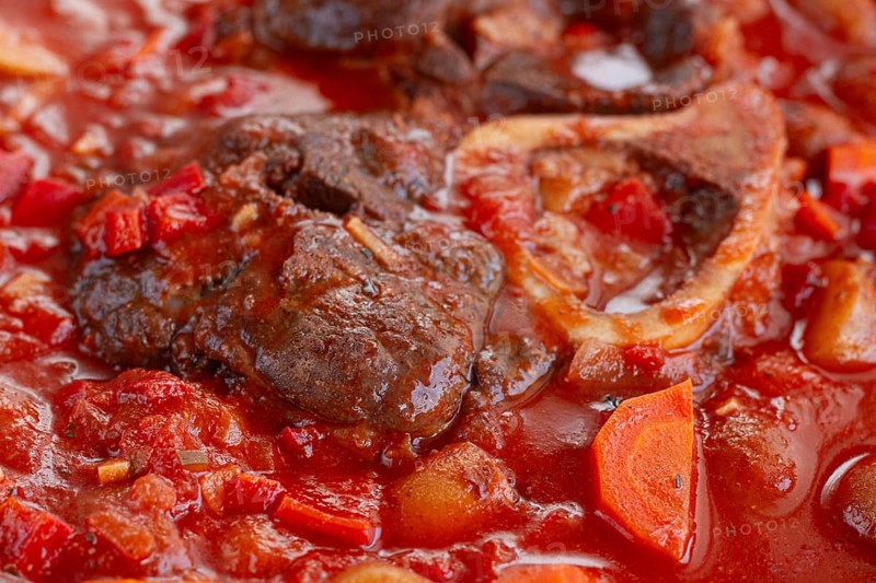 Ossobuco stew with vegetables, knuckle on the bone with new potatoes, in tomato sauce, homemade, top view, no people