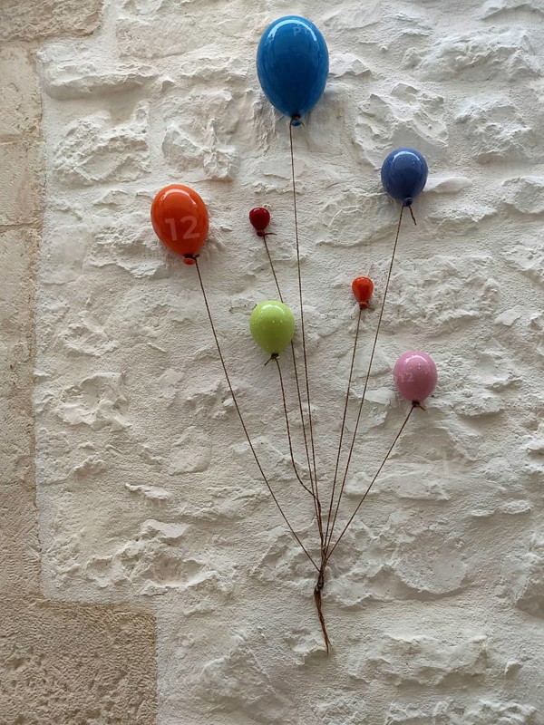 Colourful ceramic balloons as decoration on a white house wall, Cisternino, southern Italy, Italy, Europe